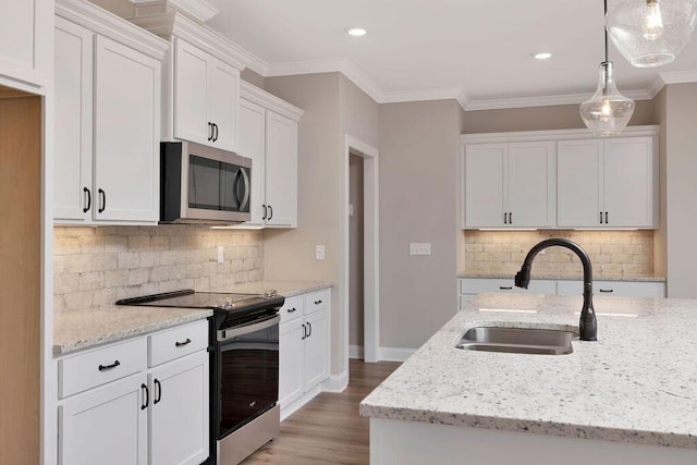 kitchen with sink, white cabinetry, hanging light fixtures, appliances with stainless steel finishes, and light stone countertops