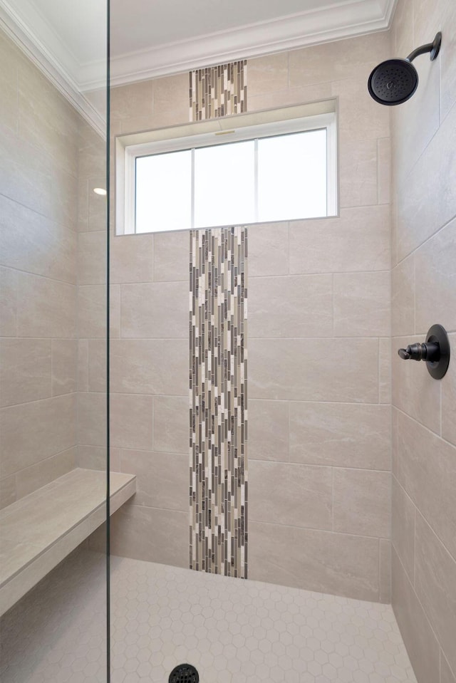 bathroom with crown molding and a tile shower