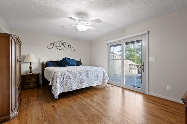 bedroom featuring a ceiling fan, a textured ceiling, wood finished floors, and access to exterior