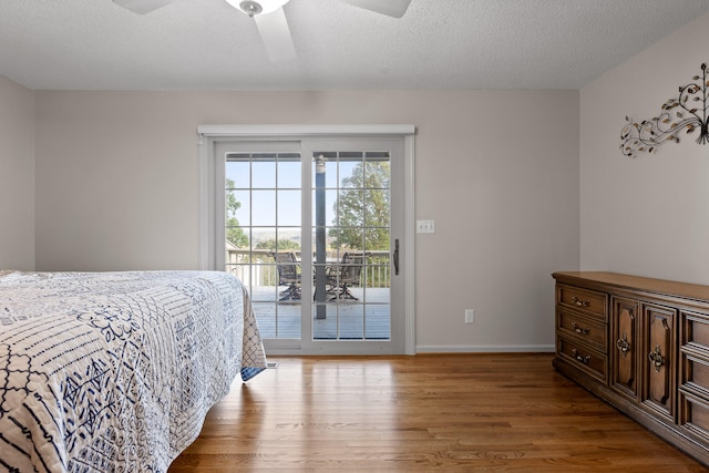 bedroom with wood finished floors, baseboards, ceiling fan, access to outside, and a textured ceiling