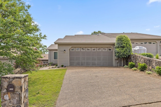 ranch-style house featuring a garage, driveway, and a front lawn