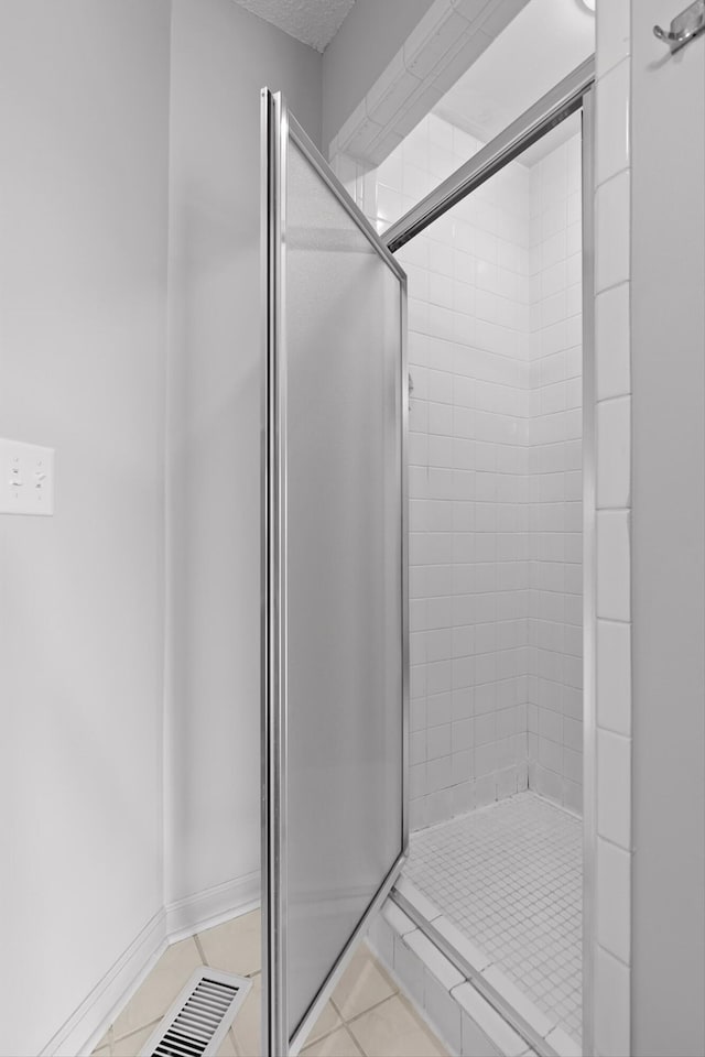 full bath with tile patterned floors and a stall shower