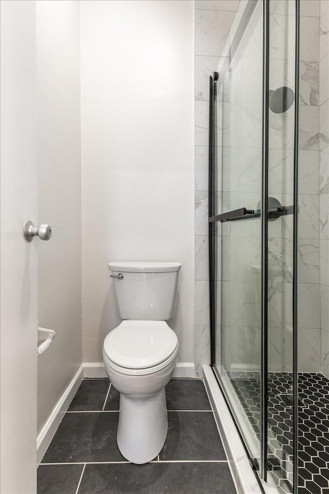 bathroom with toilet, tile patterned floors, and a shower with shower door