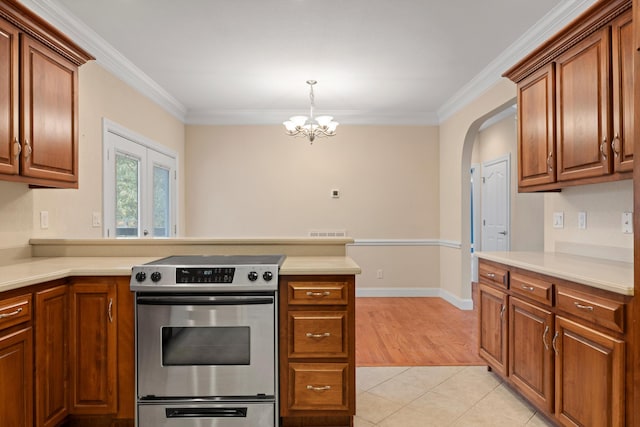 kitchen featuring an inviting chandelier, crown molding, light hardwood / wood-style floors, decorative light fixtures, and stainless steel stove