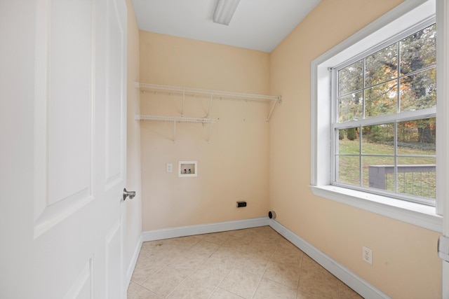 washroom with hookup for an electric dryer, washer hookup, light tile patterned floors, and plenty of natural light