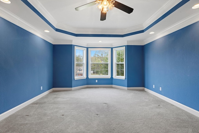 unfurnished room featuring ceiling fan, ornamental molding, carpet floors, and a tray ceiling