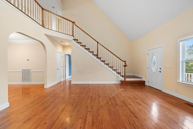 entryway with light hardwood / wood-style floors and high vaulted ceiling