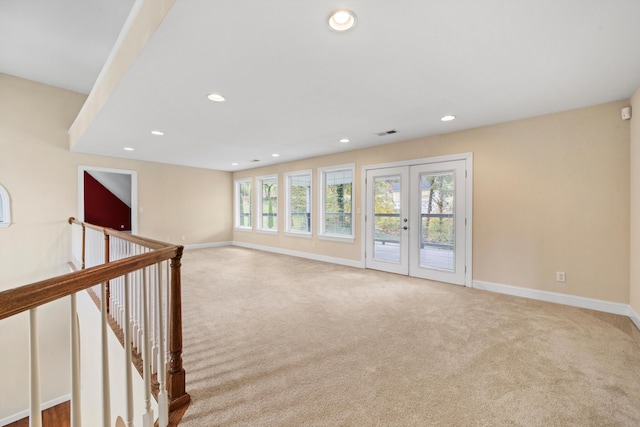 empty room featuring light carpet and french doors