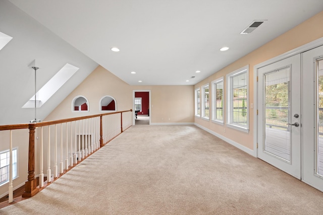 carpeted empty room with lofted ceiling with skylight