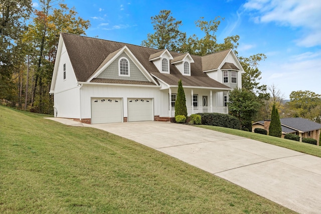 view of front facade with covered porch, a garage, and a front lawn