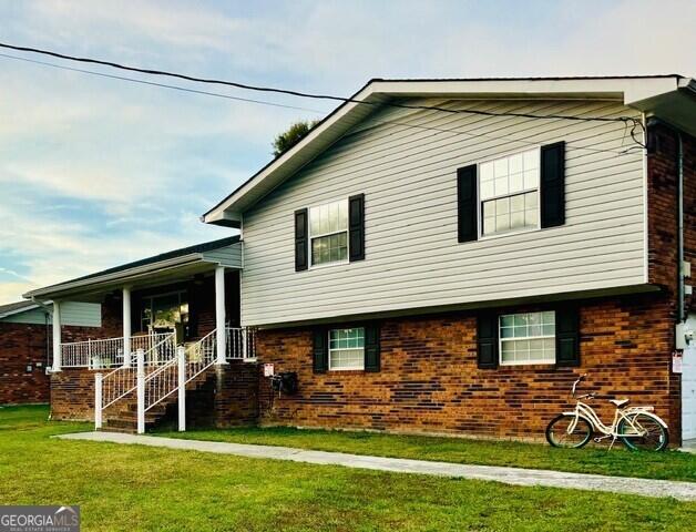 view of front facade featuring covered porch and a front yard