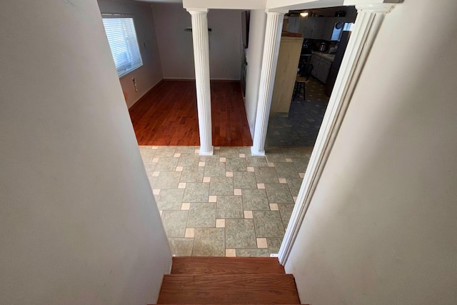 interior space with decorative columns and wood finished floors