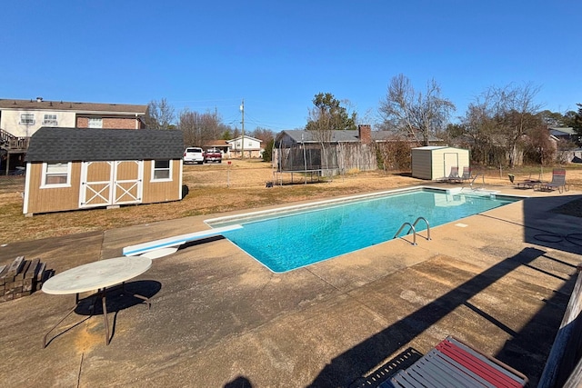 pool with a storage shed, a trampoline, fence, an outdoor structure, and a patio area