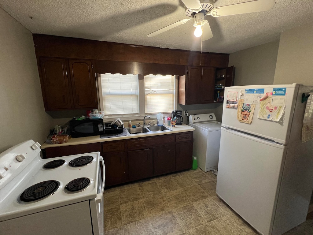 kitchen featuring dark brown cabinetry, washer / clothes dryer, a textured ceiling, and white appliances