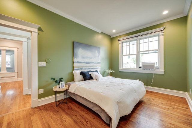 bedroom with cooling unit, hardwood / wood-style flooring, and ornamental molding