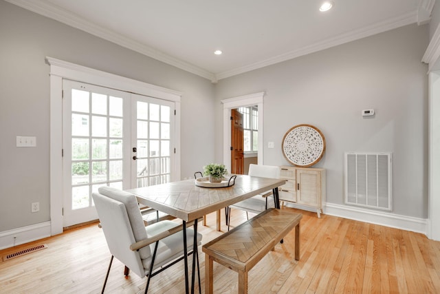 dining space with french doors, plenty of natural light, light wood-type flooring, and crown molding