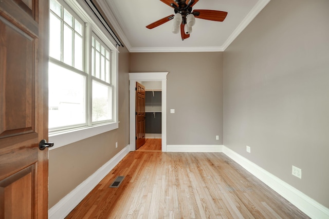 unfurnished room featuring light hardwood / wood-style flooring, ceiling fan, and crown molding