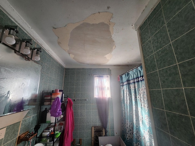 bathroom featuring curtained shower and tile walls