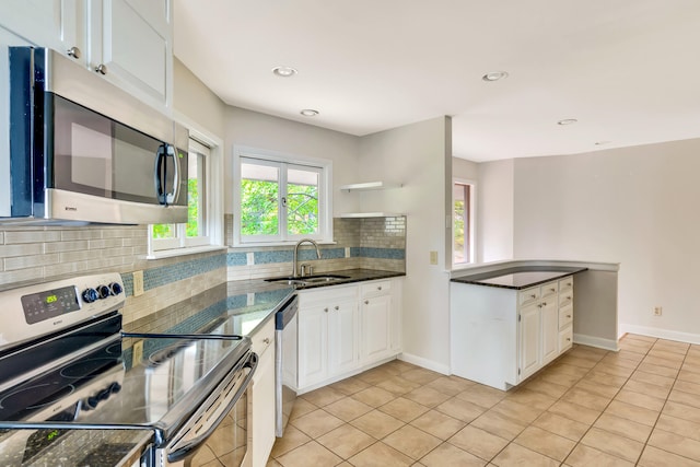 kitchen featuring white cabinetry, sink, appliances with stainless steel finishes, tasteful backsplash, and light tile patterned floors