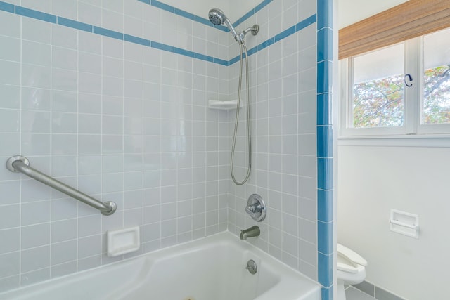 bathroom with tiled shower / bath and toilet