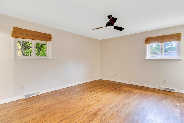 spare room featuring light wood-type flooring, a wealth of natural light, and ceiling fan