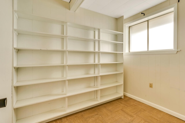 interior space featuring wooden walls and light parquet flooring