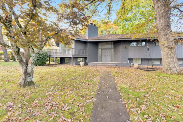 back of property with a lawn and a wooden deck