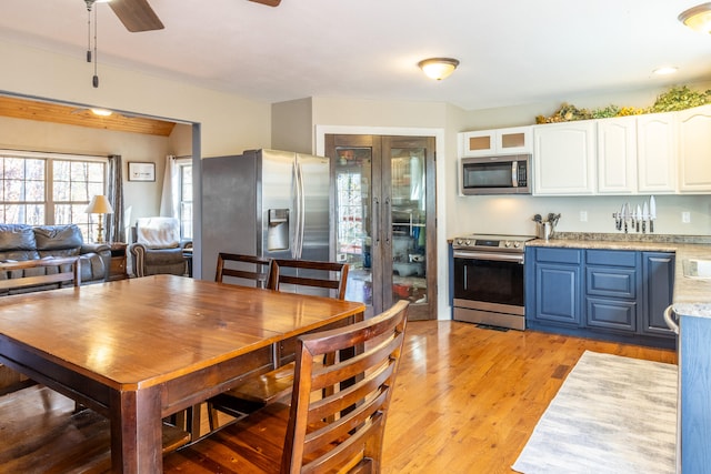 dining area with light wood-type flooring and ceiling fan