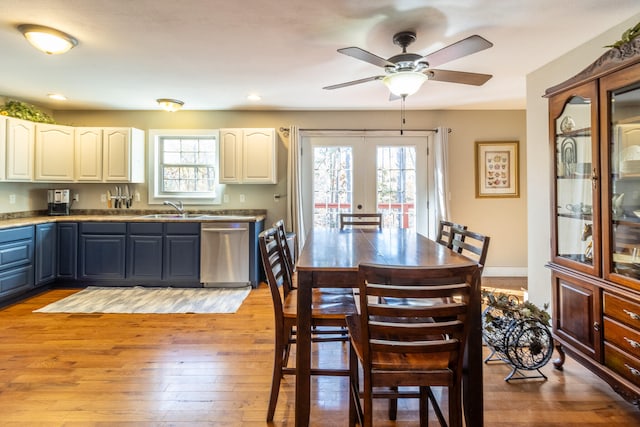 dining room with french doors, a wealth of natural light, light hardwood / wood-style floors, and sink