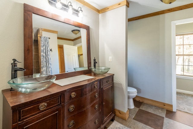 bathroom with toilet, vanity, and crown molding