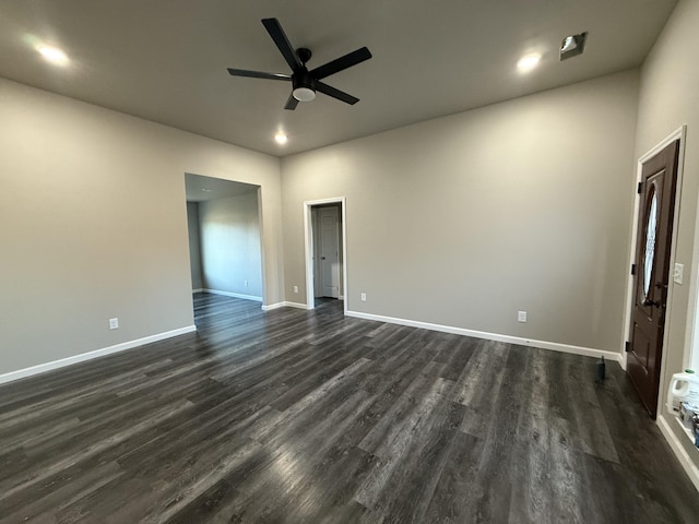 spare room with a ceiling fan, baseboards, and dark wood-style flooring