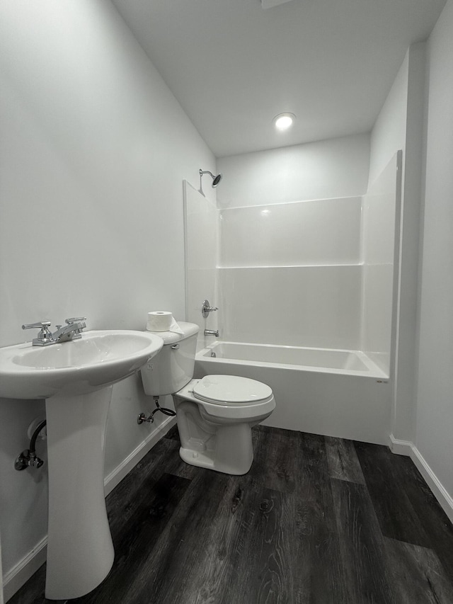 bathroom with bathtub / shower combination, wood finished floors, toilet, and baseboards