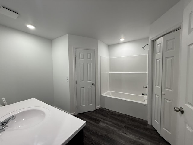 bathroom with recessed lighting, a closet, shower / bathing tub combination, vanity, and wood finished floors