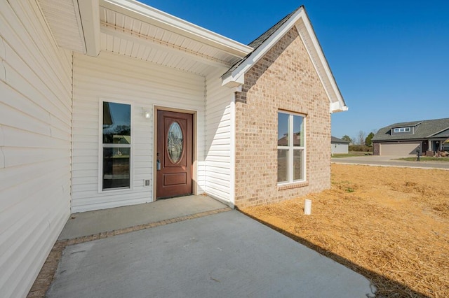 doorway to property featuring brick siding