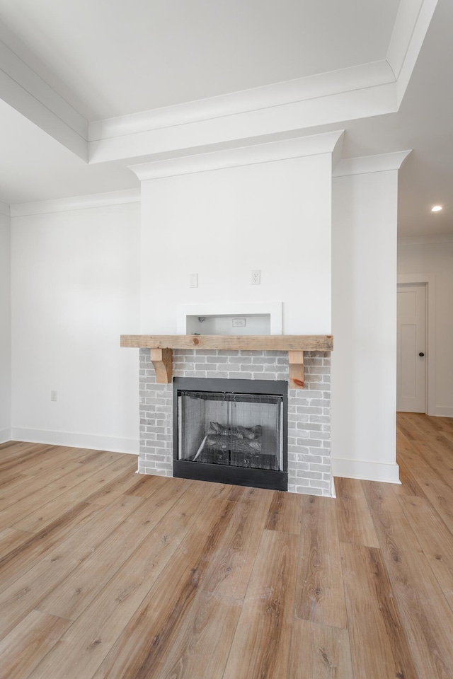 room details with crown molding, a fireplace, a raised ceiling, and hardwood / wood-style flooring