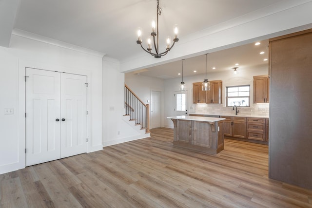 kitchen with tasteful backsplash, a kitchen island, pendant lighting, and light hardwood / wood-style floors