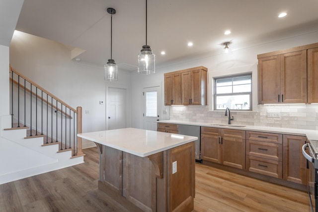 kitchen featuring sink, a breakfast bar, dishwasher, a center island, and decorative light fixtures