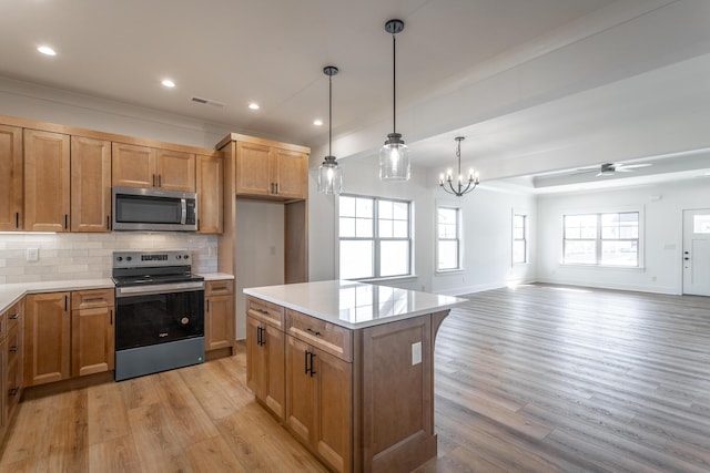 kitchen featuring a center island, light hardwood / wood-style flooring, hanging light fixtures, stainless steel appliances, and backsplash