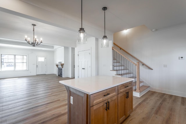 kitchen with hanging light fixtures, light wood-type flooring, and a kitchen island