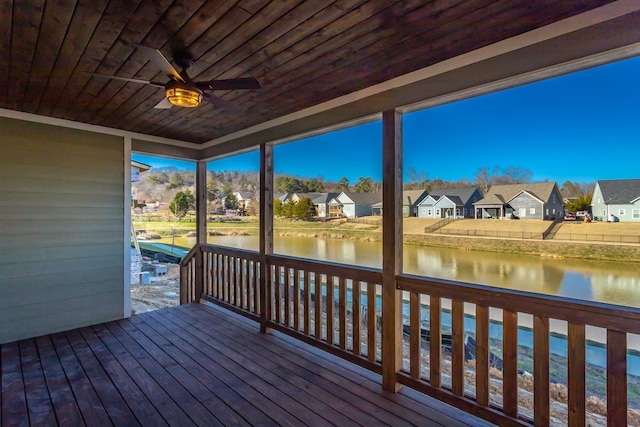 wooden terrace with a water view and ceiling fan