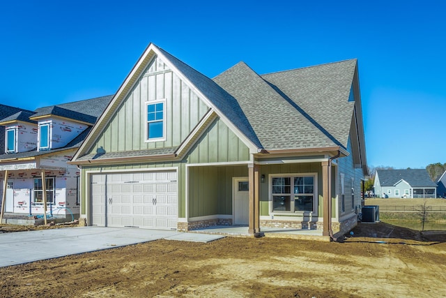 view of front of home with central AC and a garage