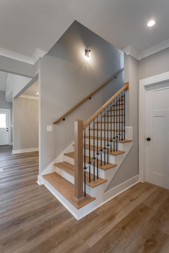 staircase featuring hardwood / wood-style flooring and ornamental molding