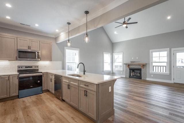 kitchen featuring sink, hanging light fixtures, plenty of natural light, stainless steel appliances, and kitchen peninsula