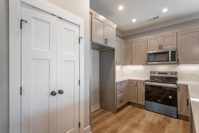 kitchen featuring tasteful backsplash, stainless steel appliances, crown molding, and light hardwood / wood-style flooring