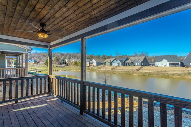 wooden deck with a water view and ceiling fan