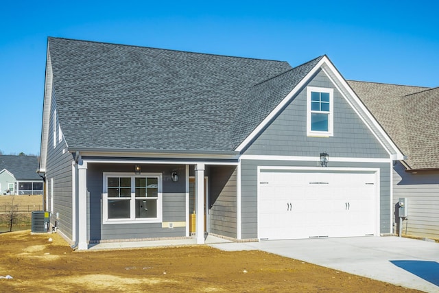 view of front of property featuring central AC and a garage