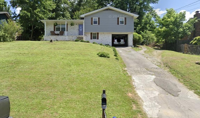 tri-level home with a porch, a front yard, and a carport