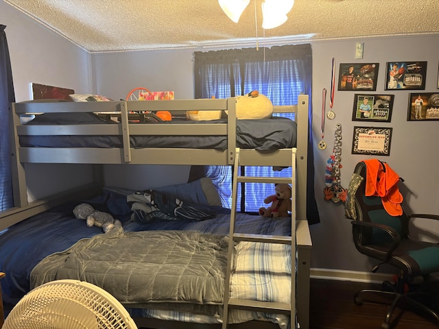 bedroom with hardwood / wood-style flooring, a textured ceiling, and crown molding