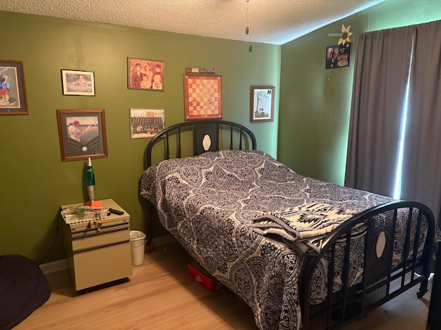 bedroom featuring a textured ceiling and light hardwood / wood-style flooring