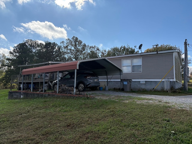 back of property featuring a carport and a lawn